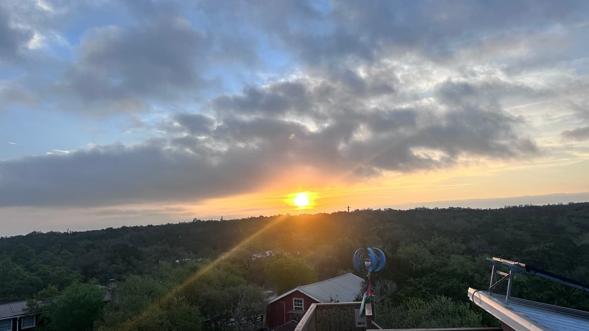 The sun rising over a wide sweep of Hill Country, seen from the rooftop deck of the Heavenly View lodge.