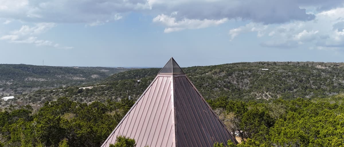 The copper pyramid rising out of cedar and oak, with hills rolling to the horizon.